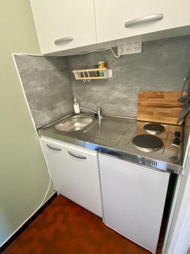 Il comprend une petite cuisine équipée d'une cuisinière et d'un évier. dans l'établissement Appartement 1 pièce, Hyper centre, Grosse Horloge, à La Rochelle