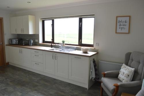 a kitchen with a sink and a window at Kilronan Self Catering - Eoropie, Isle of Lewis in Eoropie