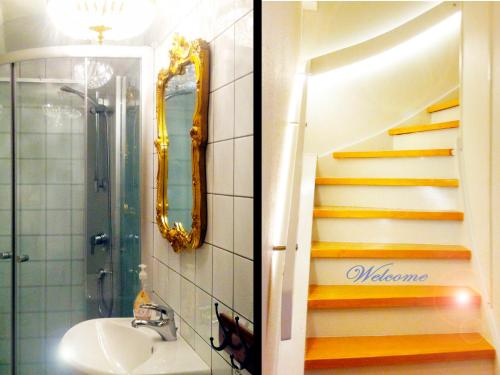 a bathroom with a sink and a staircase with a mirror at Kullabygdens Bed & Breakfast in Jonstorp