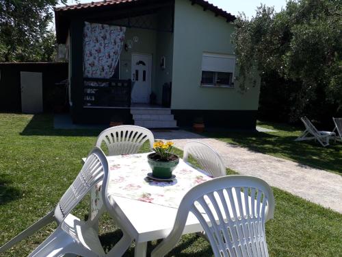 a white table with two chairs and a vase of flowers on it at Villa Elia in Skala Sotiros