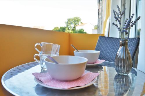 a glass table with two cups and a vase on it at Central Apartments Preko in Preko