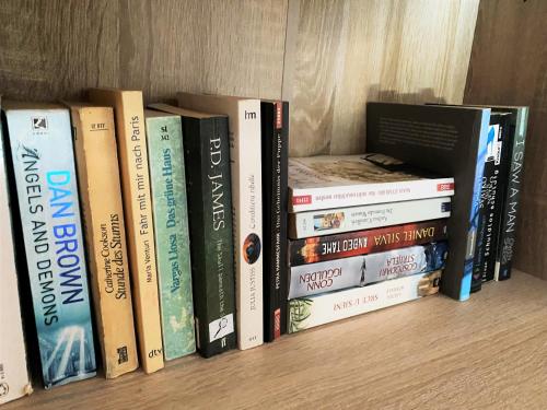 a bunch of books sitting on a shelf at Central Apartments Preko in Preko