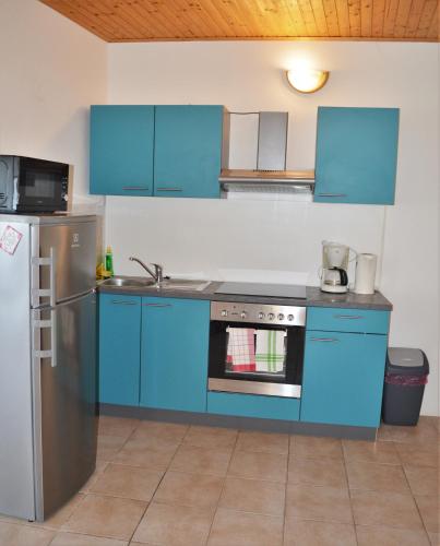 a blue kitchen with a stove and a refrigerator at Central Apartments Preko in Preko