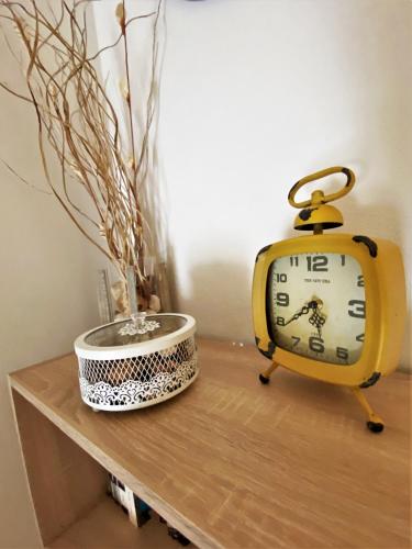 a clock sitting on a table next to a bowl at Central Apartments Preko in Preko
