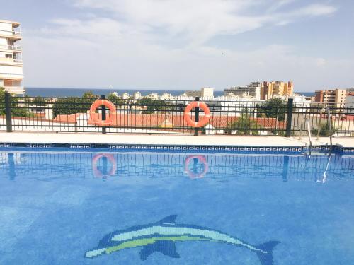 een zwembad met twee vissen geschilderd op het water bij Duplex Torremolinos Suite in Torremolinos