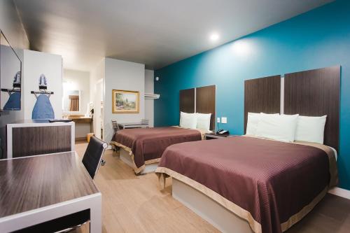 una camera d'albergo con due letti e pareti blu di Econo Lodge Inn & Suites a Channelview