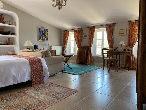 a bedroom with a bed and a table and chairs at La Bastide des Enquèses in Lorgues
