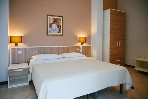 a bedroom with a large white bed and two lamps at Stella del Sud in Avola