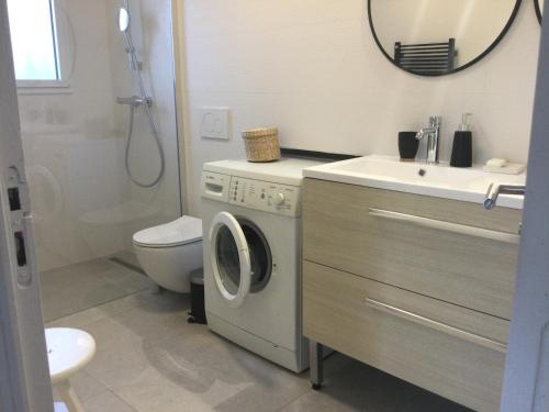 a bathroom with a washing machine and a sink at La vigie in Cavalaire-sur-Mer