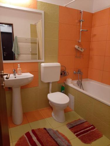 a bathroom with a toilet and a sink and a tub at ARAD Chic Apartament UTA in Arad