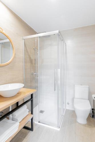 a bathroom with a shower with a toilet and a sink at Jardines Villaverde in Villaverde de Pontones