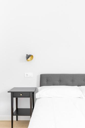 a bedroom with a bed and a nightstand with a table at Jardines Villaverde in Villaverde de Pontones