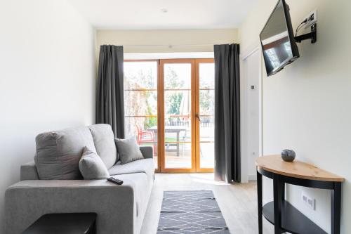 a living room with a couch and a tv at Jardines Villaverde in Villaverde de Pontones