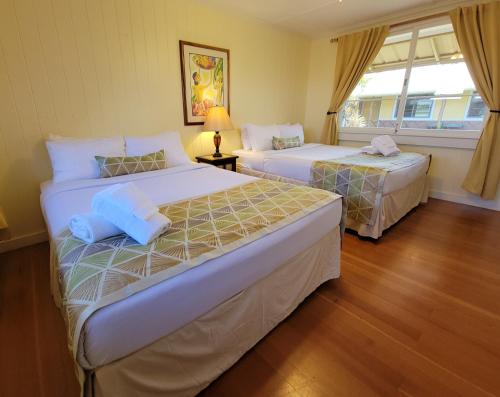 ハヴィにあるKohala Village INNのベッドルーム1室(ベッド2台、窓付)
