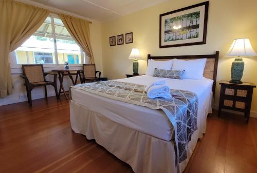 a bedroom with a large bed and a dining room at Kohala Village INN in Hawi