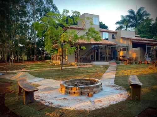 two benches and a fire pit in front of a building at Pousada do Bosque in Boa Esperança