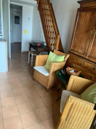 a living room with wicker chairs and a staircase at Romance in Port Grimaud in Grimaud
