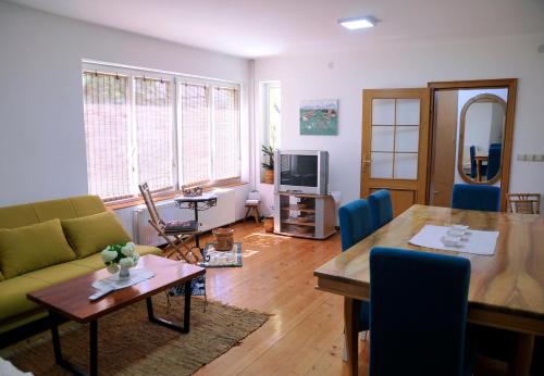 a living room with a couch and a table at Garden's apartman - Kosjerić in Kosjerić