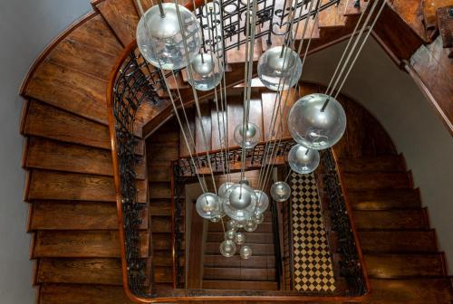 a spiral staircase with a chandelier at Z14 Boutique Residence - Krakow Old Town in Kraków