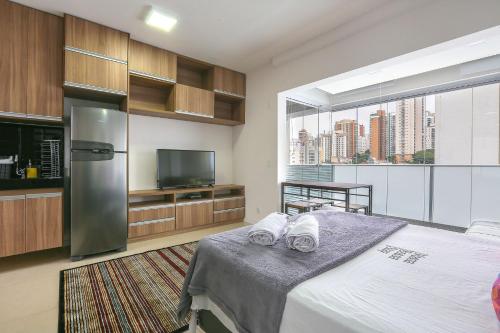 a bedroom with a bed with white towels on it at Vossa Bossa VN Turiassu in Sao Paulo