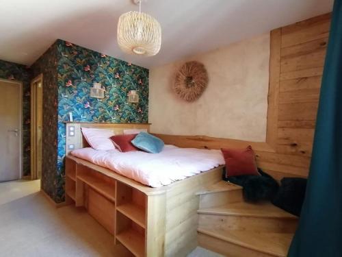 a bedroom with a bed with a wall covered in flowers at Les Herbes de la Saint Jean in Saint-Bonnet-le-Froid