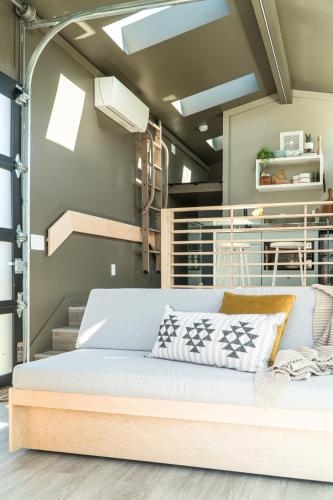 a bed in a room with stairs in the background at Ironwood Grove, Tiny House Hotel in Nashville