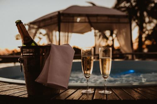 two glasses of champagne on a table near a swimming pool at Pousada Molinha in Penha