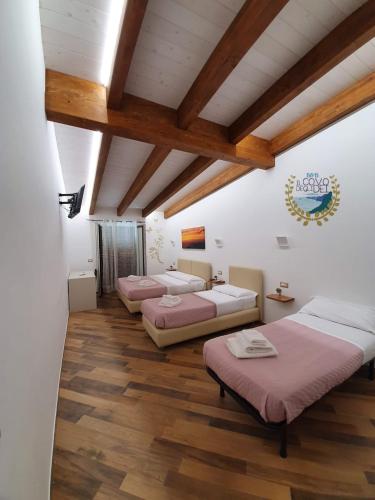 three beds in a room with wooden ceilings at Il covo degli Dei in Agerola