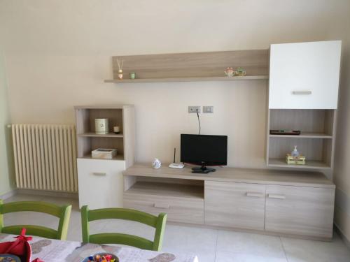 sala de estar con TV, mesa y sillas en Pelagallo, en Bagnolo Piemonte