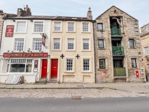 an old stone building with red doors on a street at 25 St Georges Quay in Lancaster