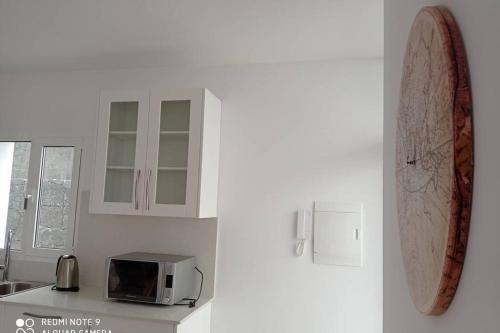 a kitchen with a counter with a microwave and a refrigerator at Precioso apartamento con terraza en Teguise in Teguise