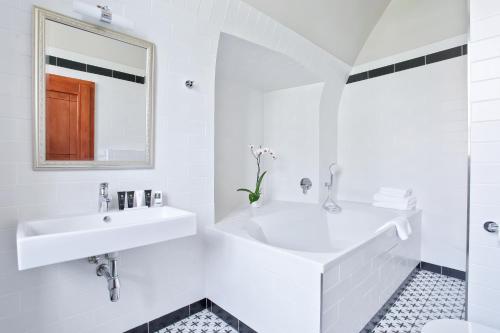 ein weißes Badezimmer mit einem Waschbecken und einem Spiegel in der Unterkunft Zámecký penzion in Poděbrady