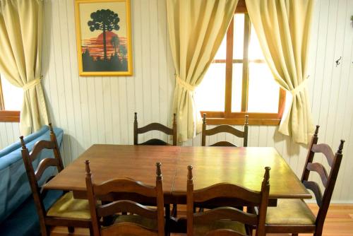 einen Holztisch und Stühle in einem Zimmer mit Fenster in der Unterkunft Pousada Bauernhof in Nova Petrópolis