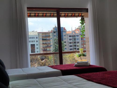 a bedroom with a large window with a view of a city at Pensión Muro de la Mata in Logroño