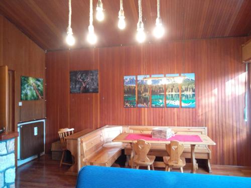 una sala da pranzo in legno con tavolo e sedie di Pisolo Cottage a Ronzone