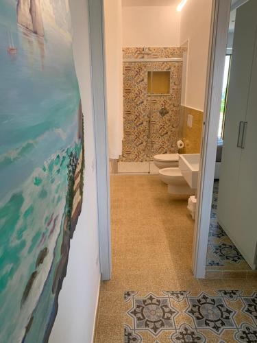 - une salle de bains avec 2 toilettes et un tableau mural dans l'établissement Il covo degli Dei, à Agerola