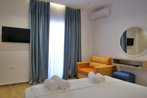 una camera d'albergo con letto, divano e specchio di Summer Point Hotel a Ksamil