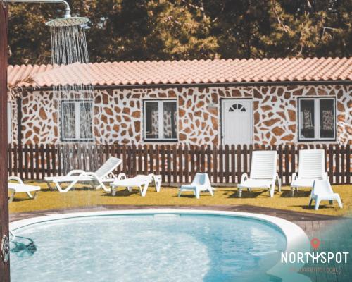 a house with a pool and chairs and a building at NorthSpot in Nazaré