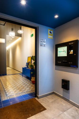 a room with a door with a tv on the wall at Four Rooms Hostel in Lugo