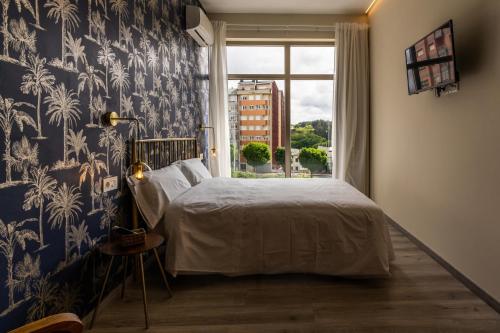 ルーゴにあるFour Rooms Hostelのベッドルーム1室(青と白の壁紙のベッド1台付)