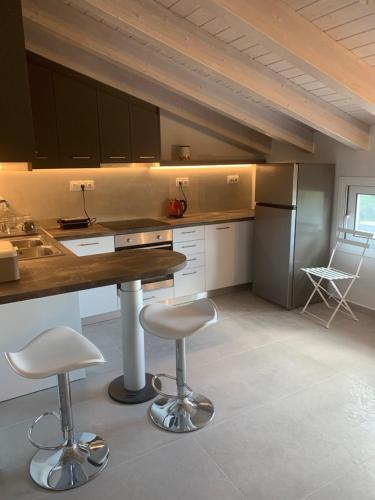 a kitchen with a counter and two stools in it at Terpsichore boutique Bright new Sofita studios and appartment in Dassia