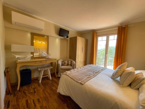 a bedroom with a bed and a desk and a window at Sotto le stelle ...il mare in Pietra Ligure