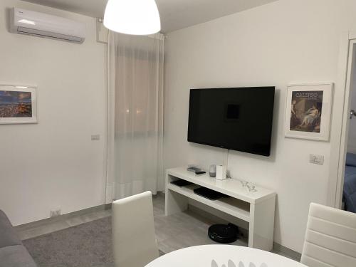 ein weißes Wohnzimmer mit einem TV an der Wand in der Unterkunft Appartamento Suite Calipso in Pozzallo
