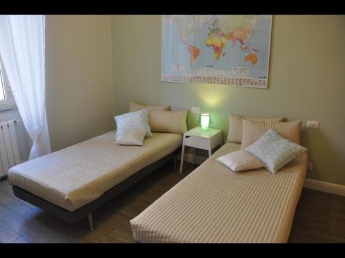 2 camas en una habitación con un mapa en la pared en Just Colosseum Suite en Roma
