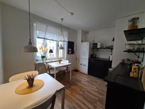 a kitchen and living room with a table and a dining room at Hotell BOULOGNE in Gävle