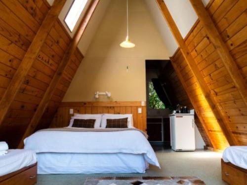 a bedroom with a white bed in a attic at Wonderland Makarora Lodge in Makarora