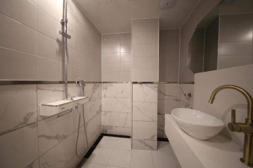 a white bathroom with a sink and a toilet at Hotel Vantt in Gwangju