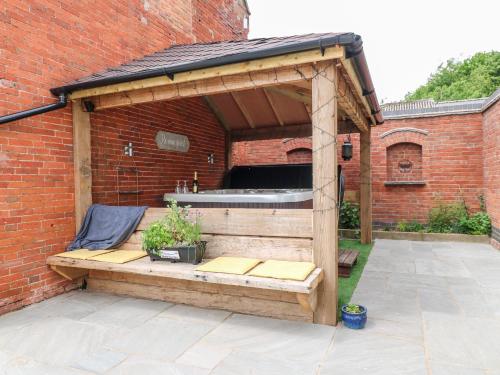 a wooden pavilion with a tub in a brick building at Fields Farm in Draycott in the Moors
