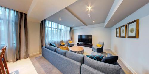 a living room with a couch and a tv at Distinction Dunedin Hotel in Dunedin