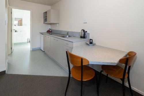 a kitchen with two chairs and a counter top at Ashburton's Regency Motel in Ashburton